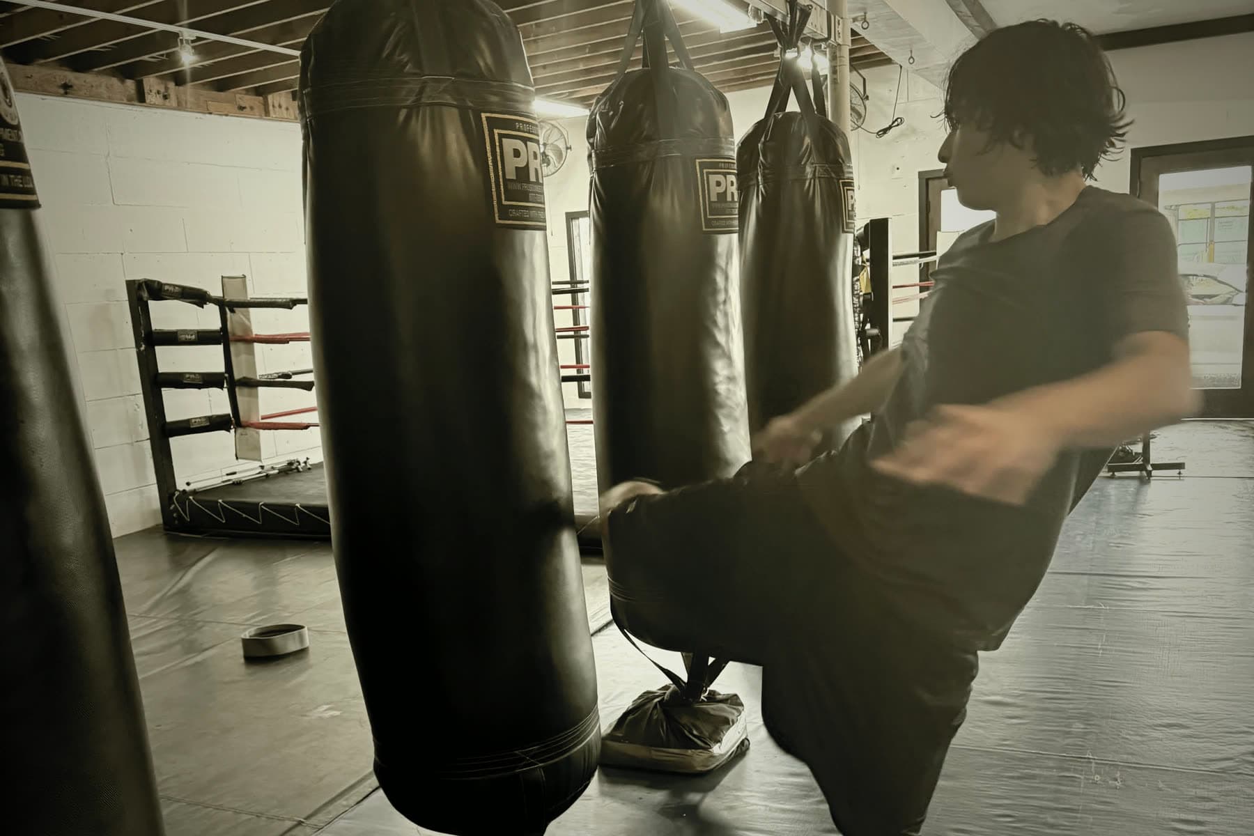 A fighter working a heavy bag on the training floor at JFM Boxing Club in Venice